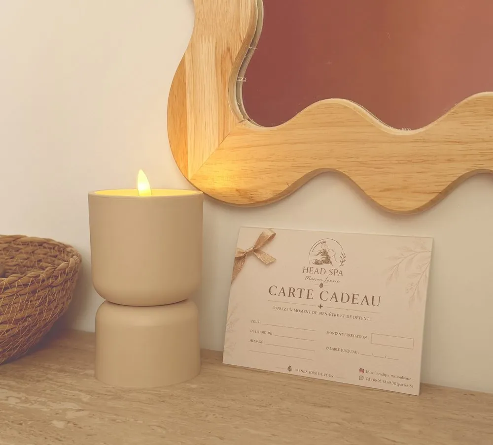 Carte cadeau Head Spa Maison Laurie posée près d'une bougie allumée